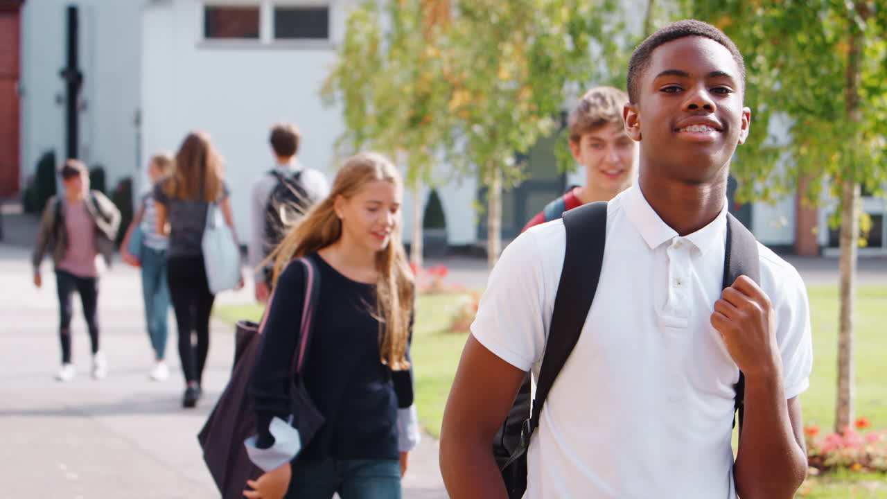 retrato de un estudiante adolescente caminando por el campus universitario