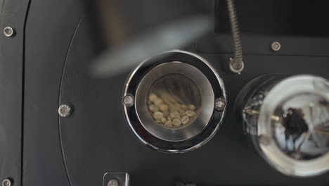 Small-Glass-Window-Opening-of-Coffee-Roasting-Machine-with-Large-Metal-Furnace,-Tumbling-inside-Vigorously-in-slowmo