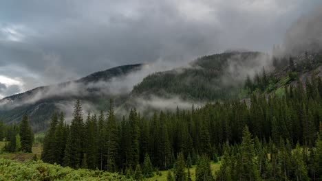 timelapse, clouds and fog above mountain hills, peaks and conifer forest, colorado usa