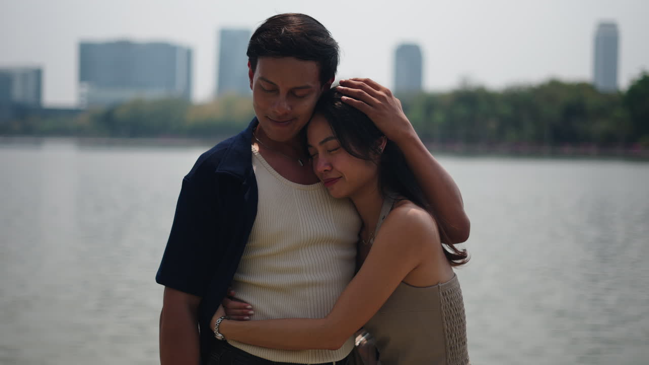 คู่รักที่กำลังโอบกอดกันริมทะเลสาบ