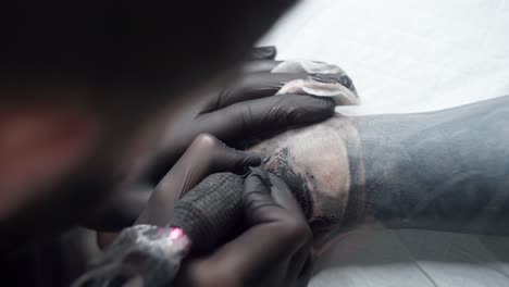maestro de pintura de tatuaje tatuaje con máquina en el brazo en el salón