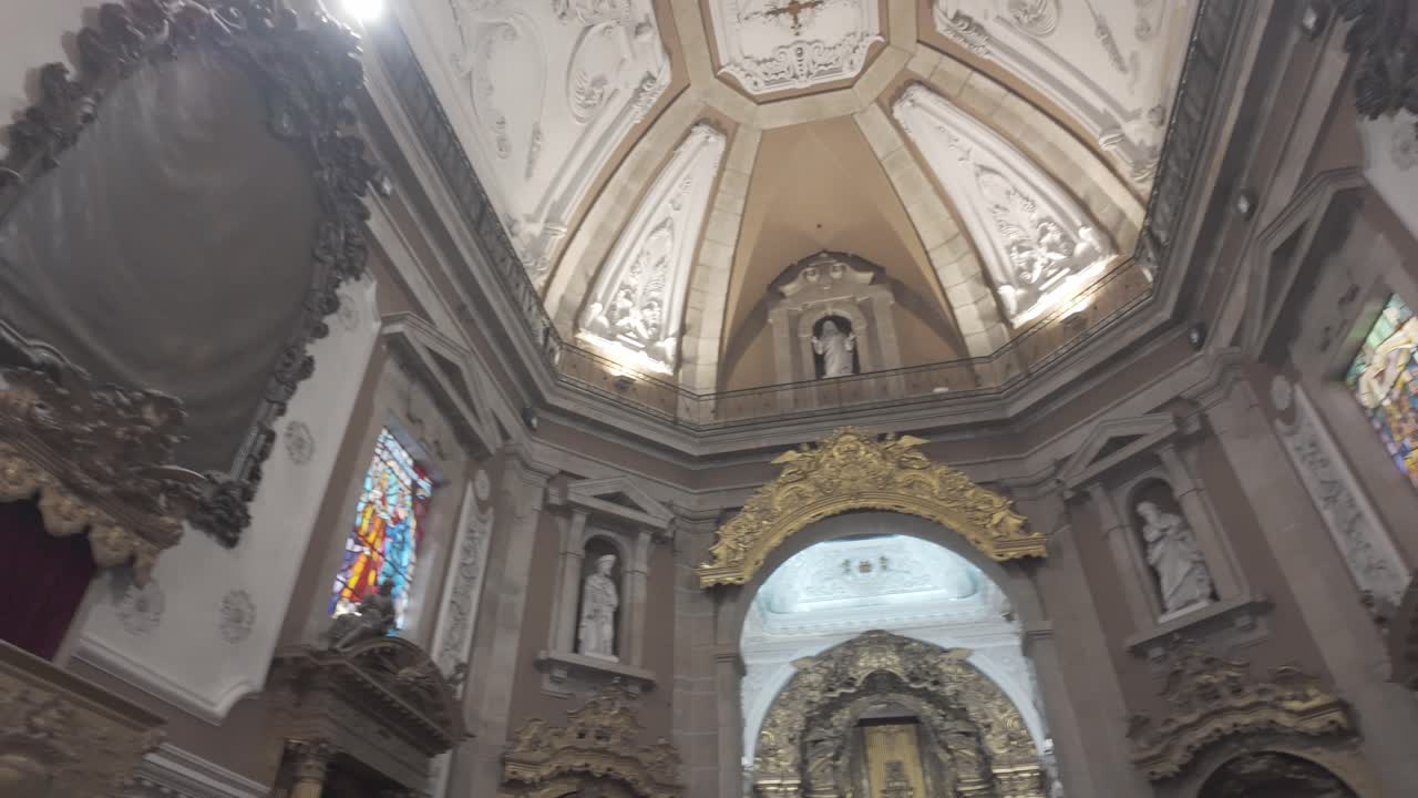 Stained glass window and ornate details inside a historic Porto church during the day