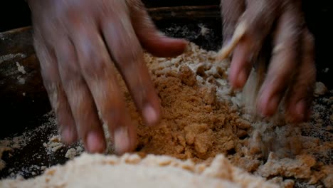 close up of hand kneading dough mixing flour