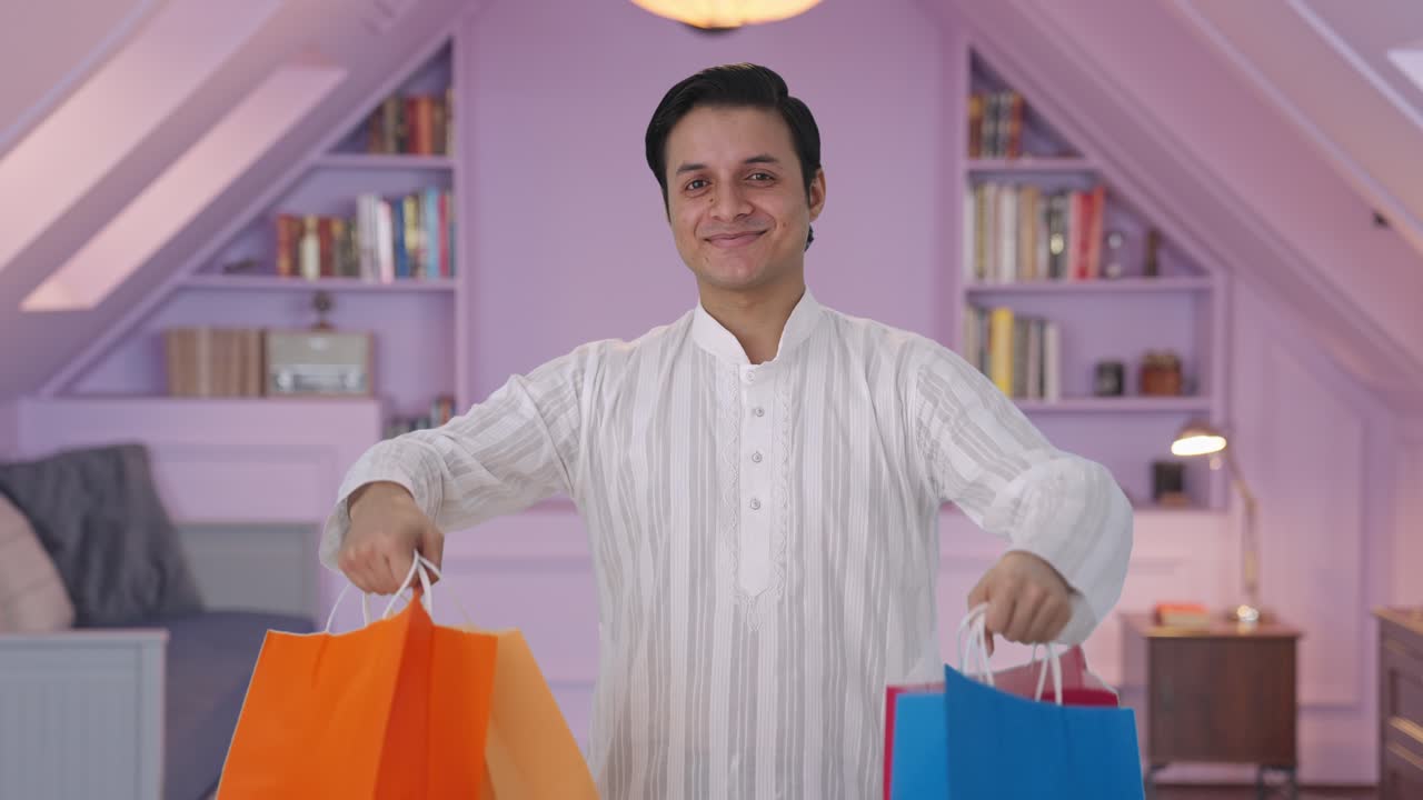hombre indio feliz con bolsas de compras