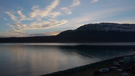 majestic sunset over bay with snow capped mountains in the background in westfjords region in iceland