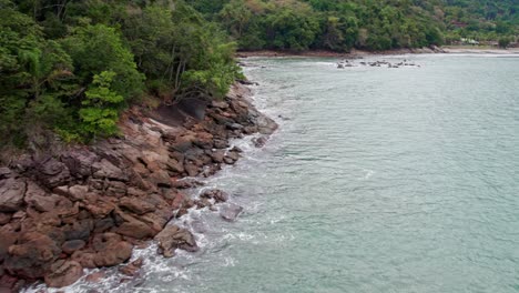 Drone-De-Baja-Altitud-Volando-Sobre-El-Agua-Del-Mar-Cerca-Del-Bosque