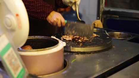 un cocinero que corta carne para un sándwich