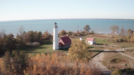 tawas, faro de michigan a lo largo del lago huron con drone bajo y avanzando