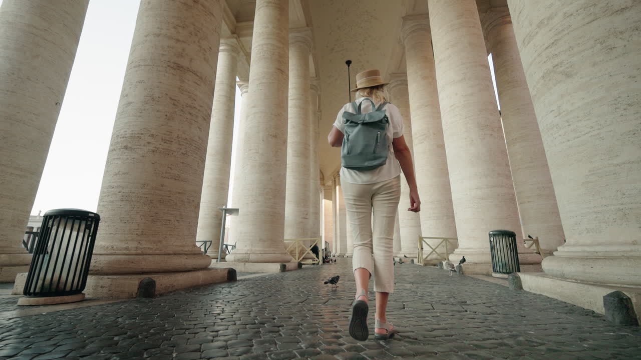 Woman walking through colonnade in St. Peter's Square, Vatican City