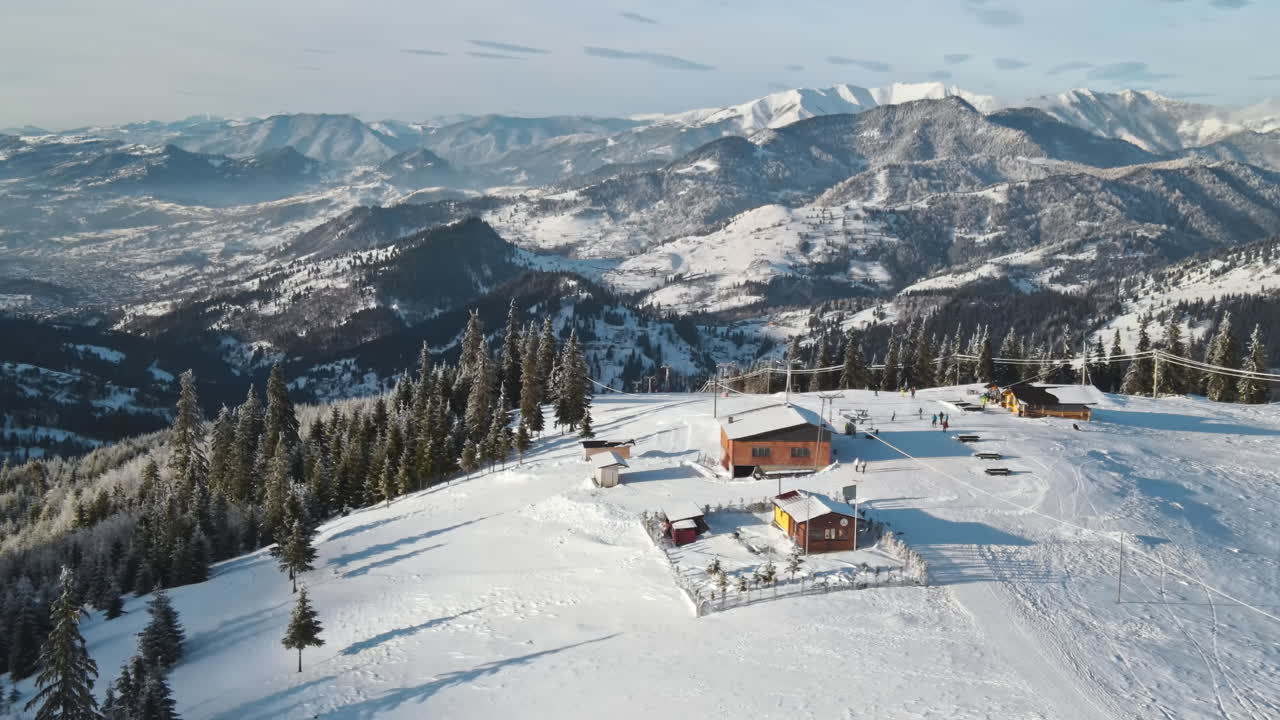 Vista aerea con drone di una pista da sci sui Carpazi in inverno, Romania. Foresta spoglia intorno, neve, funivia