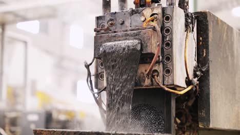 Close-up-shot-of-a-plastic-waste-product-coming-from-a-machine-in-a-recycling-centre