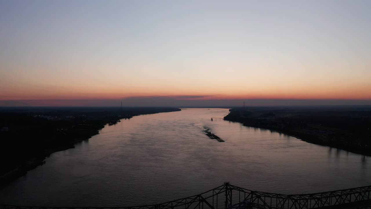 Ampia ripresa aerea in allontanamento del ponte Natchez-Vidalia sul fiume Mississippi al tramonto.