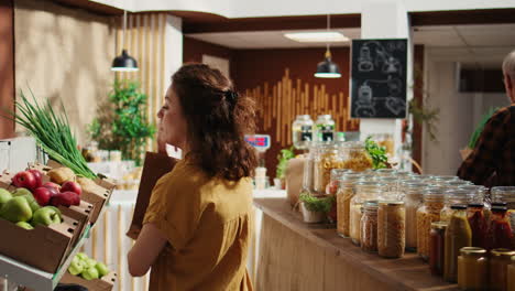 mujer en una tienda de alimentos biológicos ayudada por el vendedor