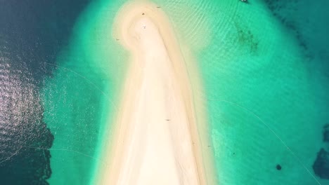 Eine-Vogelperspektive-Zeigt-Touristen,-Die-Am-Strand-Von-Zlatni-Rat-Auf-Der-Insel-Brac,-Kroatien,-Schwimmen