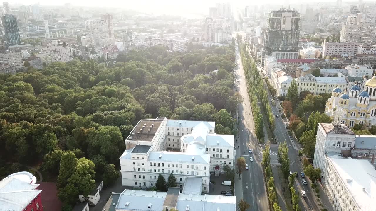 Ukraine,Kyiv,St Volodymyr Cathedral,Drone Footage starts at the famous Cathedral on a sunny day,moves across the road to the park with high trees and shows the wide perspective of the Kyiv City.