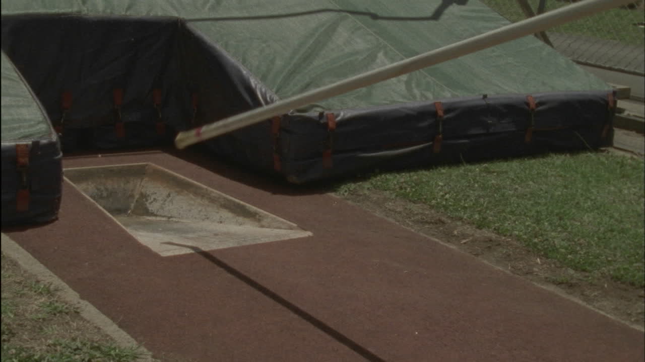 한 남자가 장대높이뛰기 시도에서 바를 떨어뜨립니다.