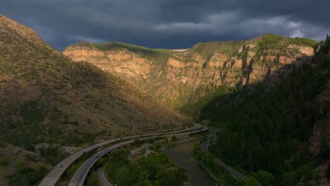 summer glenwood canyon scenic drive glenwood springs colorado river interstate i70 highway west east car traffic sun on grand mesa late afternoon dark rain thunderstorm clouds upwards motion