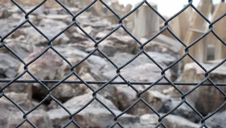 chain link security fence safeguarding coastal defence shaped marine construction block in background