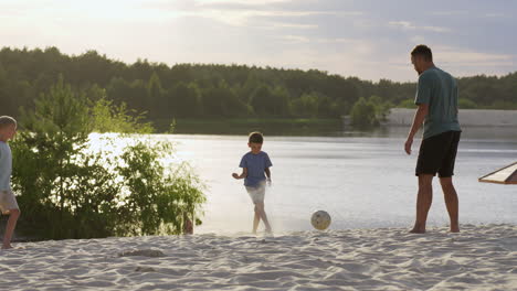 ojciec i synowie bawiący się na plaży.