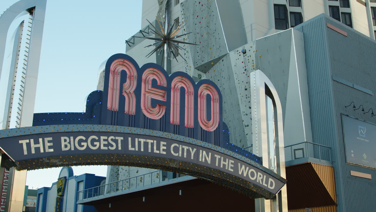 A vibrant shot captures the iconic Reno arch during the daytime, showcasing its bold colors and welcoming message against a clear blue sky, embodying the spirit of the city.