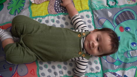 wide shot of hispanic baby on play mat