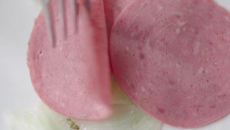 close up of a plate with sliced bologna and lettuce