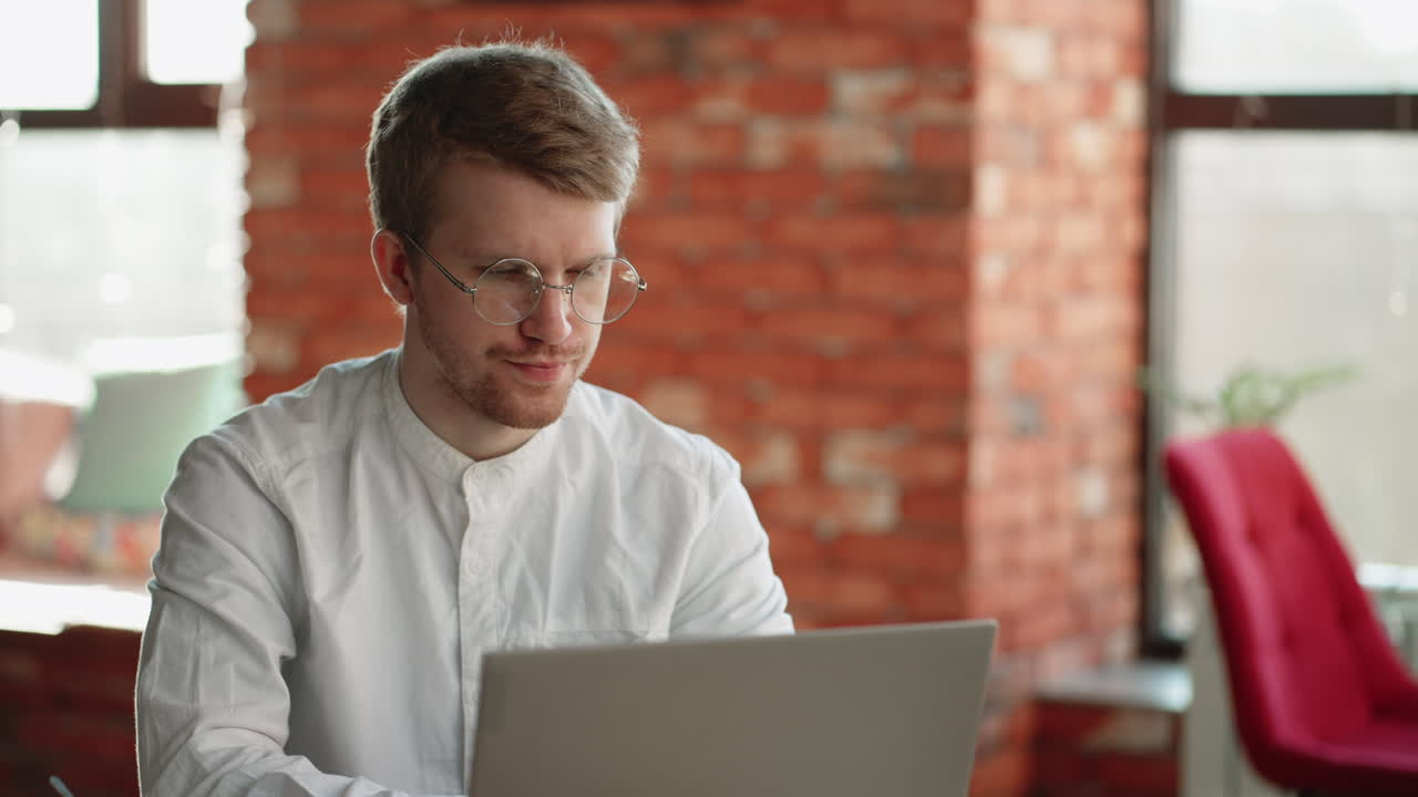 hombre pensativo está llenando currículum en línea sentado con una computadora portátil en un café freelancer y solicitante de una vacante de trabajo remota