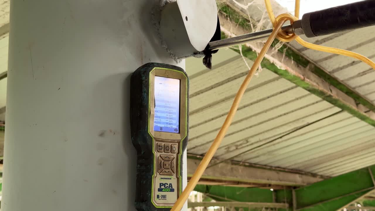 Air quality measurement tool connected to an industrial exhaust point, documenting real-time emission monitoring