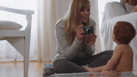 happy mother taking photo of baby using camera excited mom photographing cute toddler enjoying motherhood lifestyle making memories