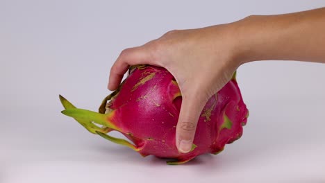 hands interacting with a dragon fruit