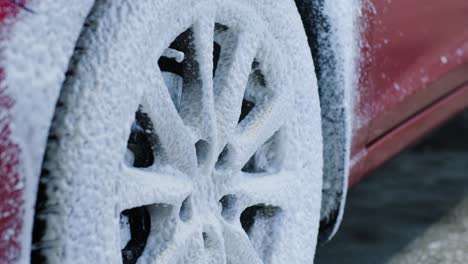 man worker washing car's alloy wheels on a car wash