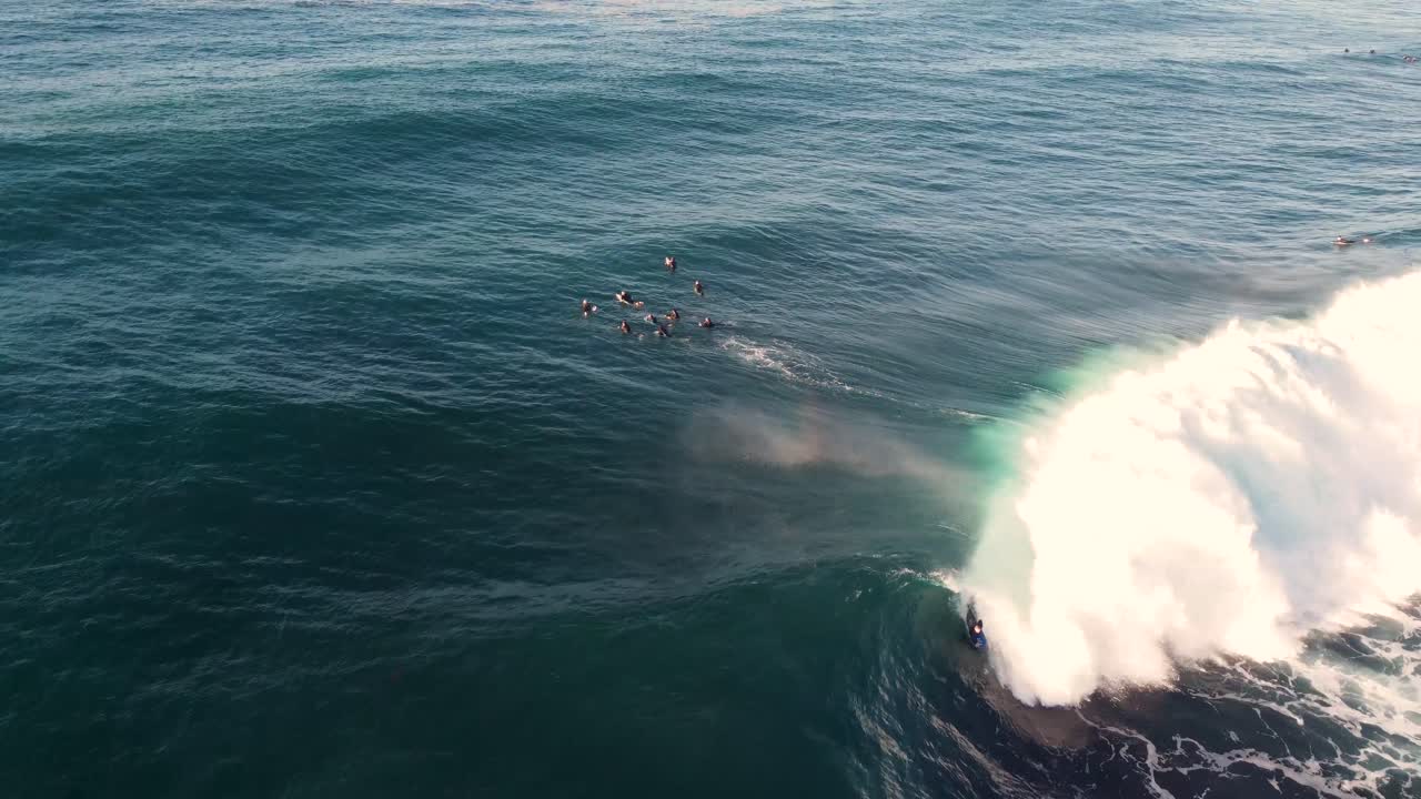 Drone aerial shot of bodyboarder surfing reef wave swell barrel Pacific Ocean Newcastle NSW Australia 4K