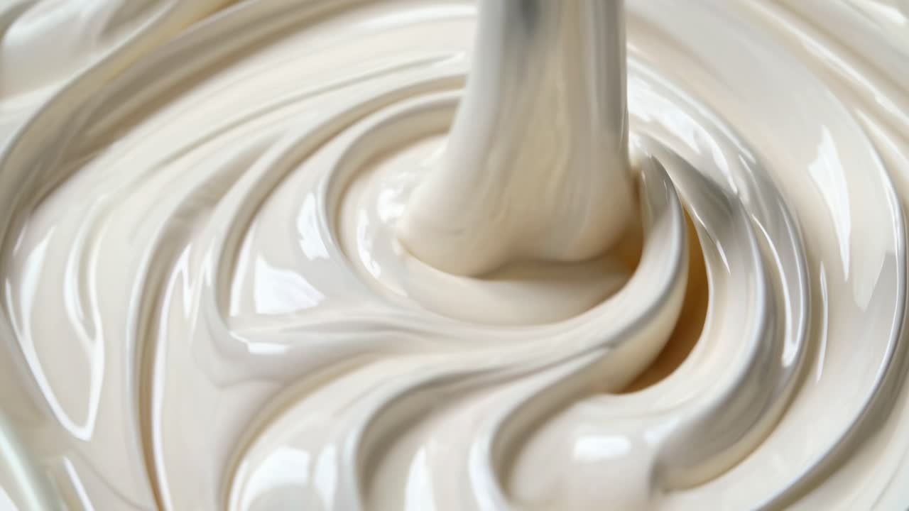 Close-up video of creamy liquid swirling, captured from a top-down angle