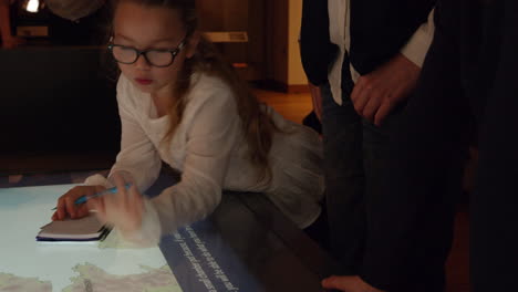 girl on museum trip looks at map and makes notes shot on r3d