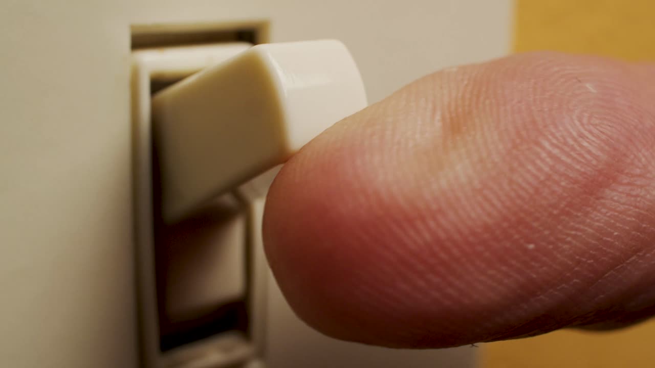 foto macro de un dedo que enciende un interruptor de luz