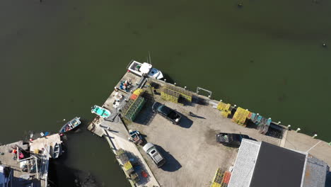 Aerial-High-Pan-Fly-Over-Drone-Footage-showing-overview-of-a-Lobster-Fishery-Warehouse-on-Maine-Coast-of-Vinalhaven,-Fox-Islands,-Knox-Couhty-Maine,-USA