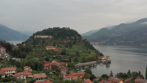 Aerial-view-of-the-city-of-Bellagio-with-a-green-mountain-filled-with-buildings-in-the-background