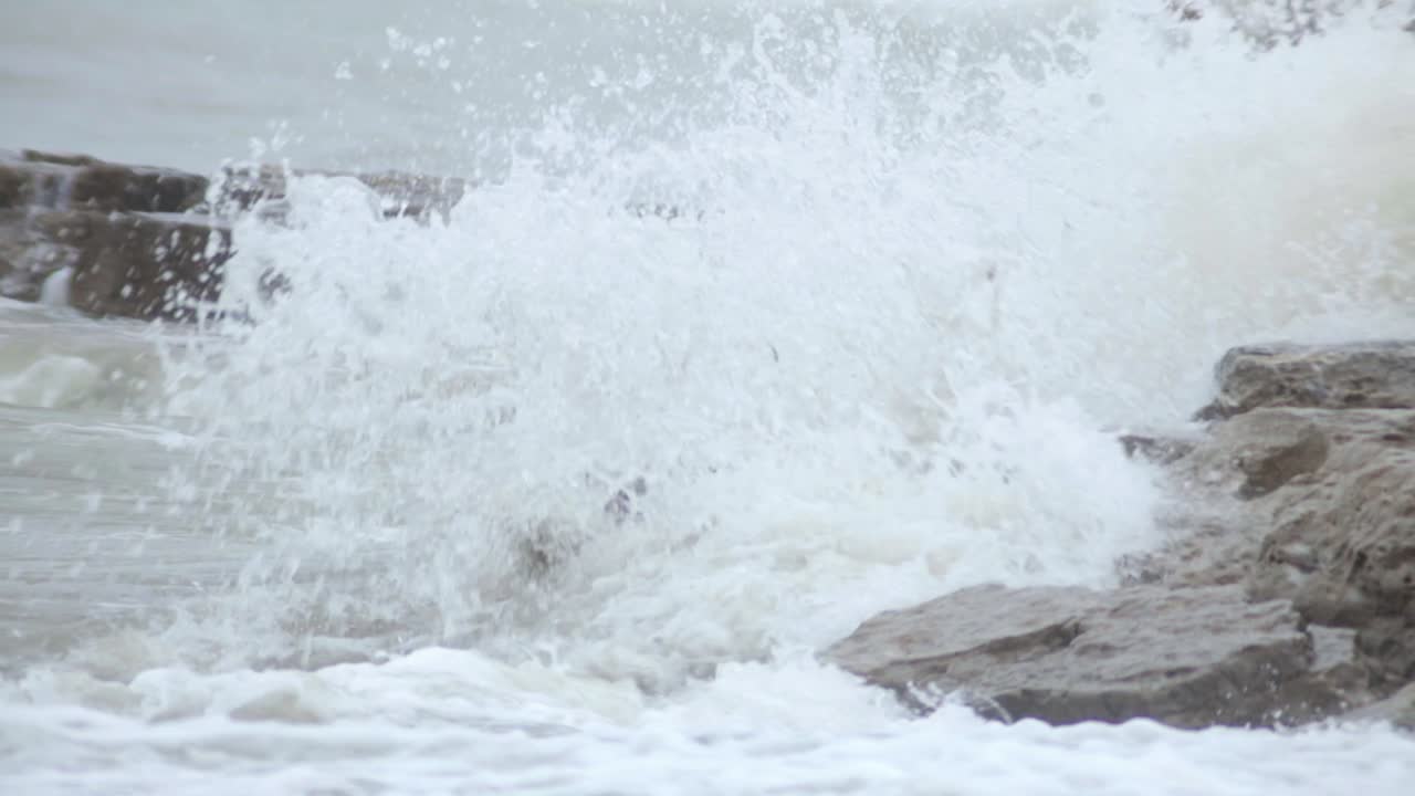 grandes olas de agua casi cubriendo el montón de pilas de mar durante el día