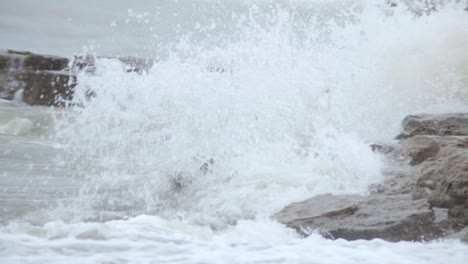 Grandes-Olas-De-Agua-Casi-Cubriendo-El-Montón-De-Pilas-De-Mar-Durante-El-Día