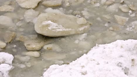 Nahaufnahme-Eines-Haufens-Durchscheinender-Eisbrocken,-Die-Auf-Einem-Bett-Aus-Weißem-Schnee-Liegen