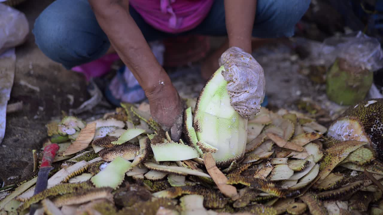 Close up of the process of people making food from pieces of young jackfruit at a traditional market
