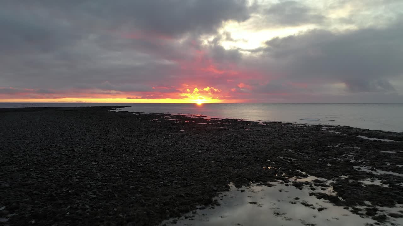 Colorful sunset with dramatic clouds during low tide at Reykjanes peninsula