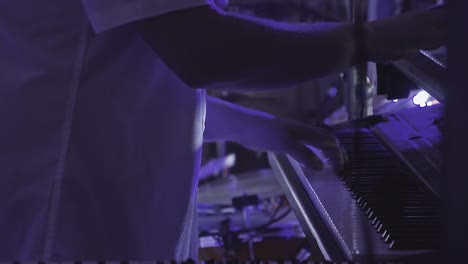 keyboardist plays on several musical instruments at a concert as part of a musical group close up