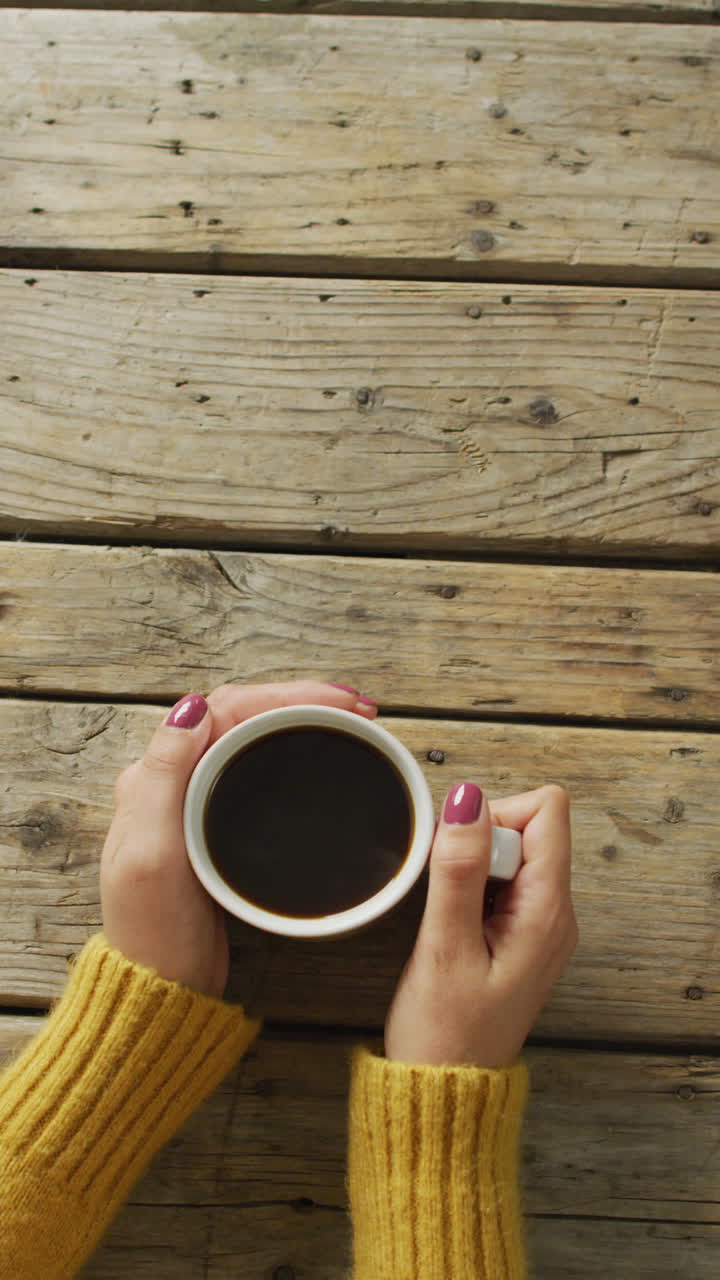커피 한 잔 을 들고 있는 백인 여자 의 클로즈업 의 수직 비디오