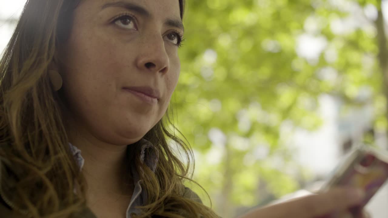 mujer joven concentrada enviando mensajes de texto en el teléfono inteligente.