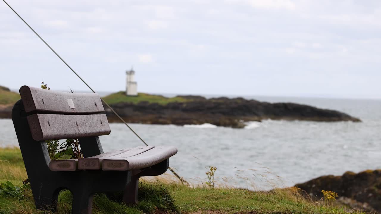 바다 건너편의 등대를 바라보는 벤치