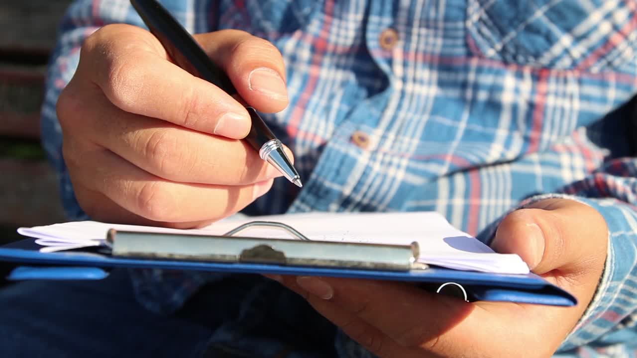 escribiendo un diario con cuadernos en el parque de césped
