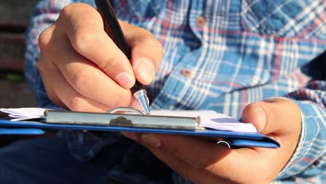 escribiendo un diario con cuadernos en el parque de césped