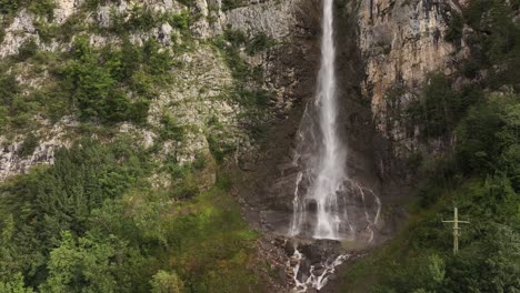 Close-up aerial view of Seerenbach Falls cascading down a rocky cliff in Betlis, Amden, Switzerland