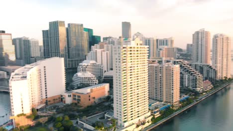 aerial view of downtown miami urban city center south of the miami river brickell at sunrise, panning shot to the left